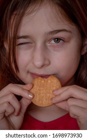 Portrait Of Beautiful, Lovely, L Child Girl, Bites Cookies On Red Background. Girl Eating Cookies. Girl 9 Years Old Portrait. The Concept Of Food And Man. Teenager