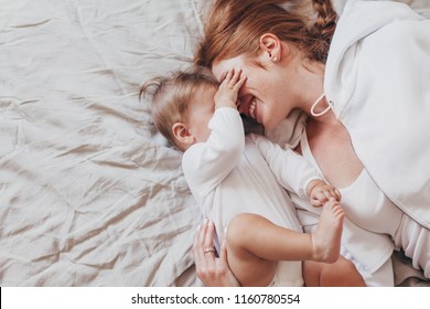 Portrait Of Beautiful Loving Mom Playing First Games With Her 8 Months Old Baby In Bedroom, Top View