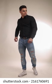 Portrait of a beautiful man guy brunet in the studio in a jeens and shirt, big strongman, sport street style, muscle male. torso