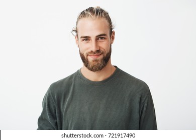 Portrait of beautiful mature blonde bearded guy with trendy hairdo in casual grey shirt smiling and looking in camera.