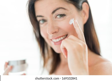 Portrait Of A Beautiful Mature Lady Preventing Wrinkles By Using A Luxurious Face Lotion