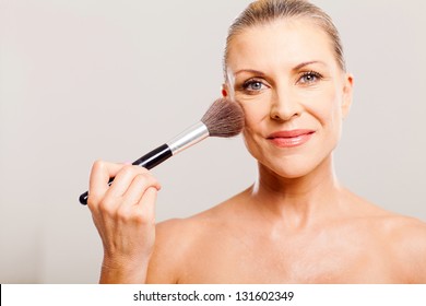 Portrait Of Beautiful Mature Woman Applying Make Up