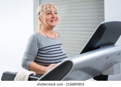 Portrait Of Beautiful Mature Woman Jogging On Treadmill At Home