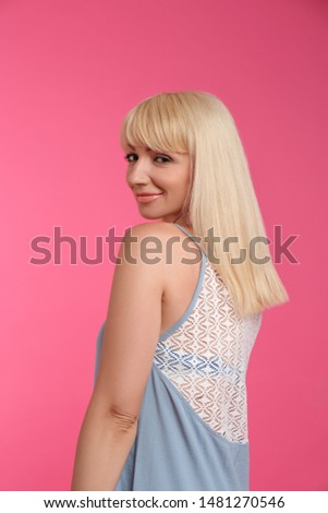 Portrait of beautiful mature woman on pink background