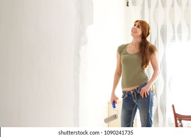 Portrait Of Beautiful Mature Woman Painting Interior Wall With Paint Roller In New House