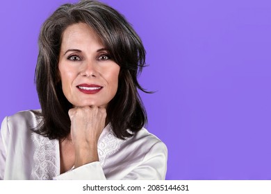Portrait of a Beautiful Mature Woman Posing with Her Hand Under Her Chin Wearing a White Robe