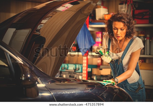 Portrait of a\
beautiful mechanic woman working on a car in an auto repair shop.\
instagram image filter retro\
style