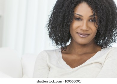 Portrait Of A Beautiful Middle Aged African American Woman Sitting At Home Relaxing And Smiling