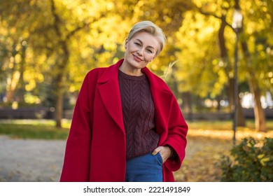 Portrait of a beautiful middle-aged woman in a red autumn coat