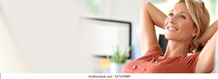 Portrait of beautiful middle-aged woman relaxing in office