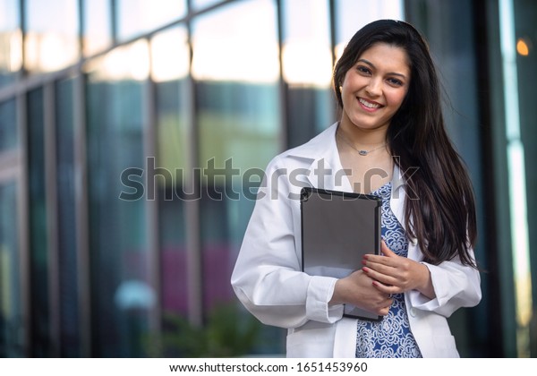 Portrait of a beautiful mixed ethnicity\
Hispanic Indian woman, medical professional, student, intern, or\
assistant at the\
workplace