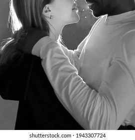 Portrait Of Beautiful Mixed Race Couple, Embracing, Smiling, Kissing And Looking At Each Other. Couple In Love Standing In Doorway. No Faces. Black And White. Face To Face.