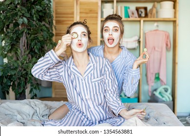 Portrait of beautiful models in beauty-mask for face with tied up brunette hair. Cute women having perfect beauty day and posing on comfortable bed. Blurred background - Powered by Shutterstock