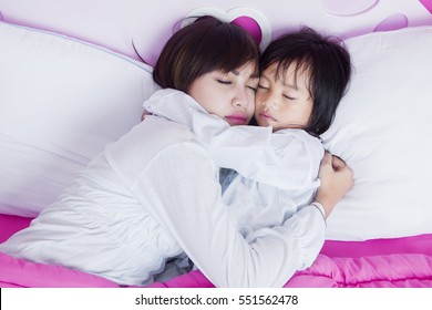 Portrait Of Beautiful Mother And Cute Child Sleeping Together On The Bed 