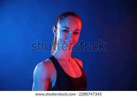 Similar – Close up front upper body portrait of one middle age athletic woman in sportswear in gym over dark background, looking at camera and smiling