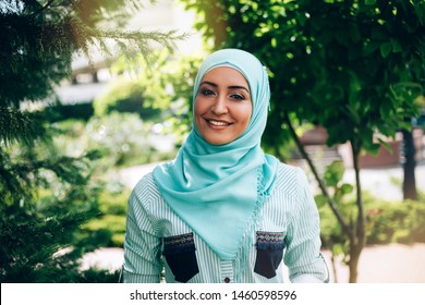 Portrait of beautiful muslim woman at street. Woman wearing hijab in the lights of sun outdoor.