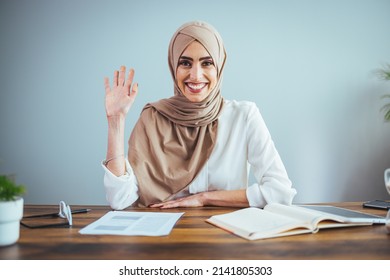 A Portrait Of A Beautiful Muslim Woman Waving Her Hand And Looking At The Camera. The Woman Is Not Tired From Work In Her Home Office.