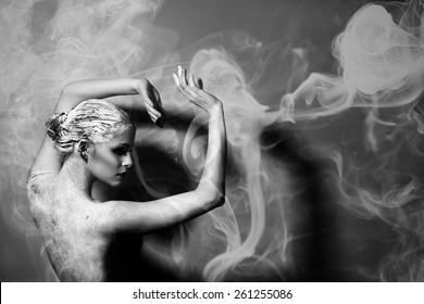  Portrait of the beautiful naked woman. Abstract smoke. Black and white photography. Body care. Spa. Mask of clay
