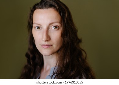 Portrait of a beautiful natural woman of middle age. Girl with green eyes without makeup not retouching. Non-standard appearance mix race.  thin features of the face are elongated. Brunette curly hair