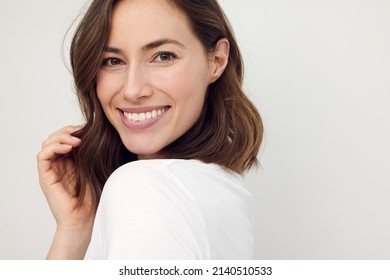 Portrait of beautiful naturally brunette woman, smiling and looking in camera with white teeth. Close-up portrait of cute female girl isolated on white background. - Shutterstock ID 2140510533