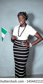 Portrait of beautiful Nigerian woman dressed in Tiv traditional attire with a flag of Nigeria