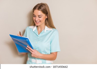 Portrait Of Beautiful Nurse Writing Notes.