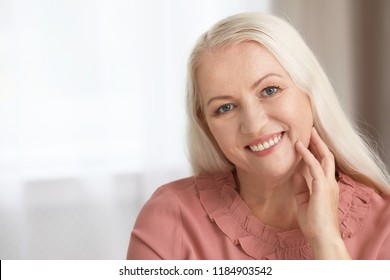 Portrait of beautiful older woman against blurred background with space for text