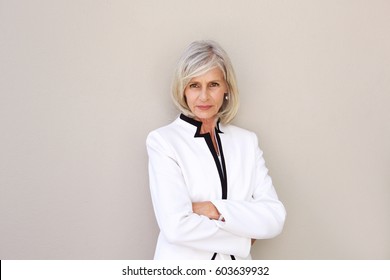Portrait of beautiful older woman staring and standing with arms crossed