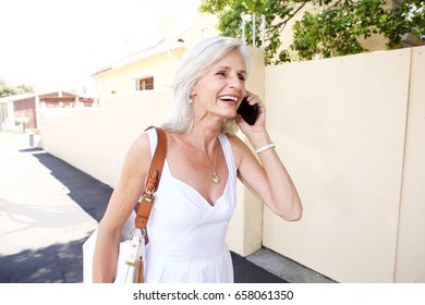 Portrait Of Beautiful Older Woman Walking And Talking On Mobile Phone