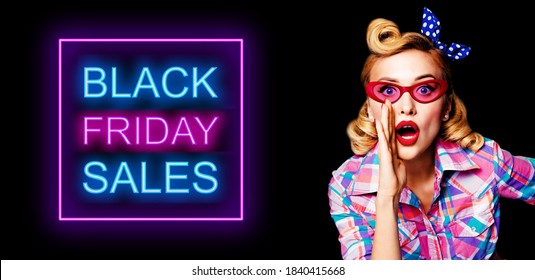 Portrait of beautiful pinup woman in red glasses, holding hand near open mouth and saying something. Blond haired pin up girl at retro vintage studio concept. Black Friday sales neon light sign.