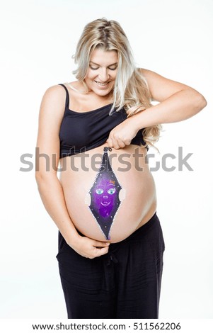 Portrait of beautiful pregnant woman with baby painted on belly.