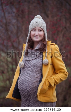 Portrait of beautiful pregnant woman on a cold autumn or winter day