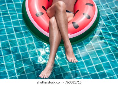 Portrait Beautiful Pretty woman girl in bikini plays inflatable float watermelon ring buoy in swimming pool blue water at resort, close up crossed legs, Holiday concept