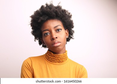 Portrait of a beautiful sad Afro woman wearing a yellow turtleneck sweater.