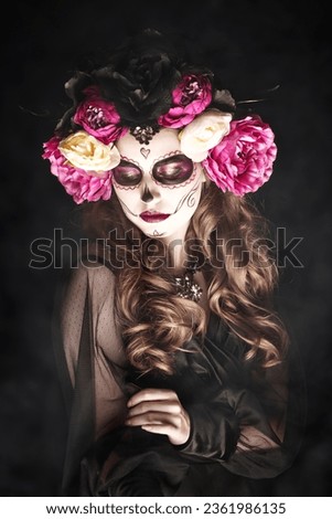 Portrait of a beautiful and scary girl with Calavera Сatrina make-up on a black background. Symbol of the Day of the Dead. Halloween. Sugar skull girl. Dia de los Muertos.