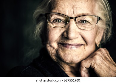 Retrato de una bella anciana con elegantes gafas sonriendo a la cámara.