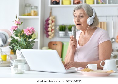 Portrait of beautiful senior woman singing with microphone