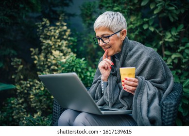 Portrait of a beautiful senior woman using laptop outdoors. - Powered by Shutterstock