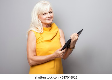 Portrait Of Beautiful Senior Woman Using Tablet. Lady With Long Grey Hair.