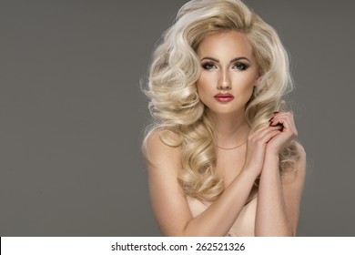 Portrait of beautiful sensual blonde woman with long curly hair. Beauty photo. 