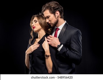 Portrait Of Beautiful Sensual Couple In Elegant Clothes Hugging Isolated On Black