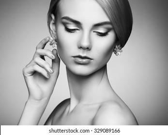 Portrait of beautiful sensual woman with elegant hairstyle.  Perfect makeup. Blonde girl. Fashion photo. Jewelry. Black and white
