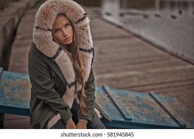 Portrait of beautiful and sexy woman in dark hood with fur