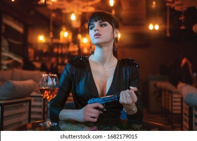Portrait of a beautiful sexy woman with a gun in her hands.