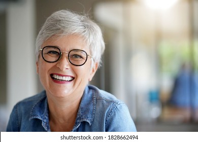 Portrait Of A Beautiful Smiling 55 Year Old Woman With White Hair