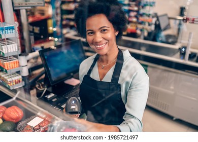 Portrait of beautiful smiling African American cashier working at a grocery store.