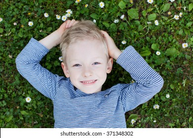 portrait of beautiful smiling boy lying on the grass from above - Powered by Shutterstock
