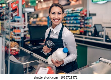 Portrait von einem wunderschönen lächelnden Kassierer, der in einem Lebensmittelgeschäft arbeitet.