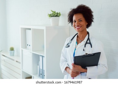 Portrait of beautiful smiling female african american doctor standing in medical office. Health care concept, medical insurance, copy space. - Powered by Shutterstock