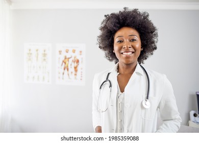 Portrait of beautiful smiling female african american doctor standing in medical office. Health care concept, medical insurance, copy space. Smiling female doctor with lab coat 